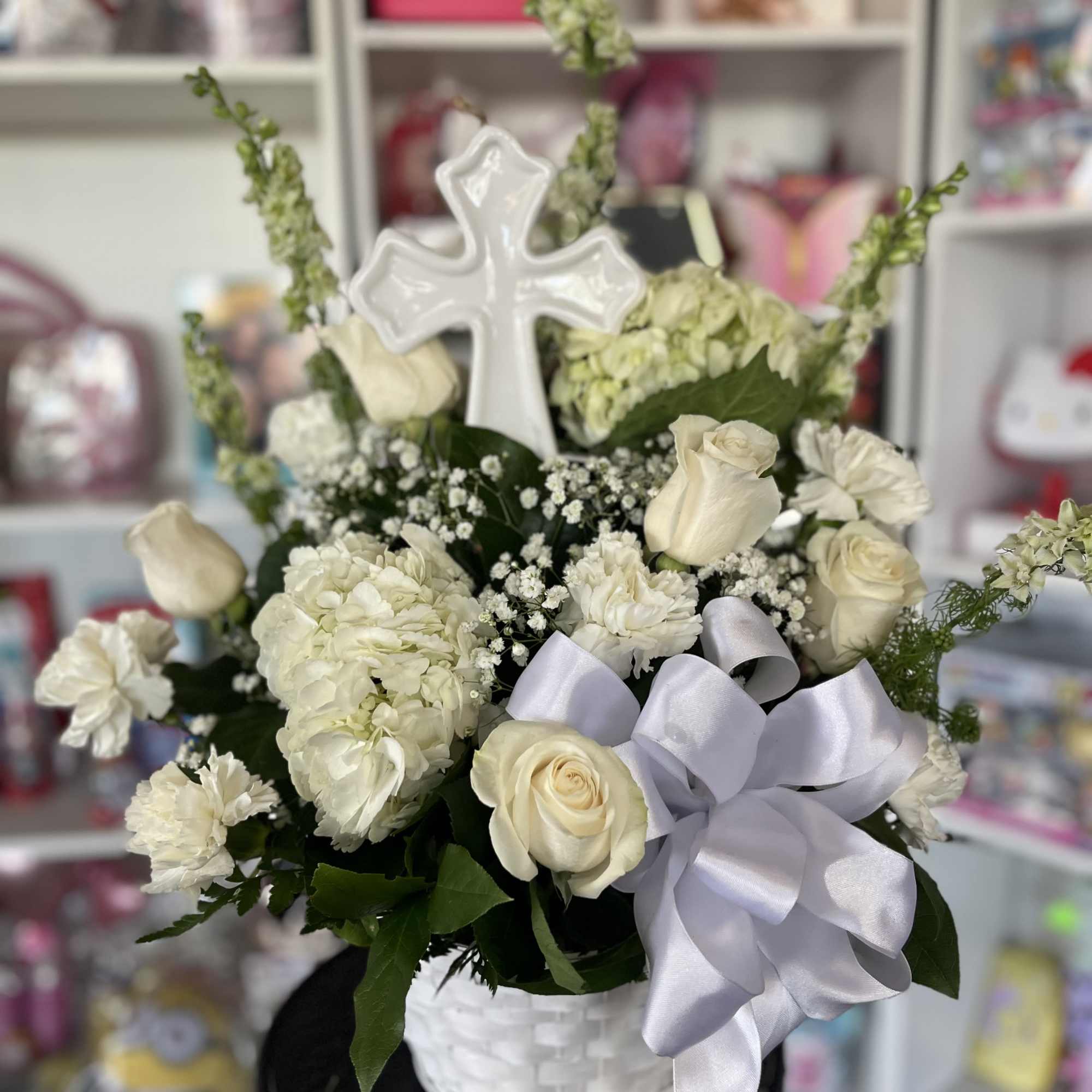 fresh white flowers in basket with large cross 