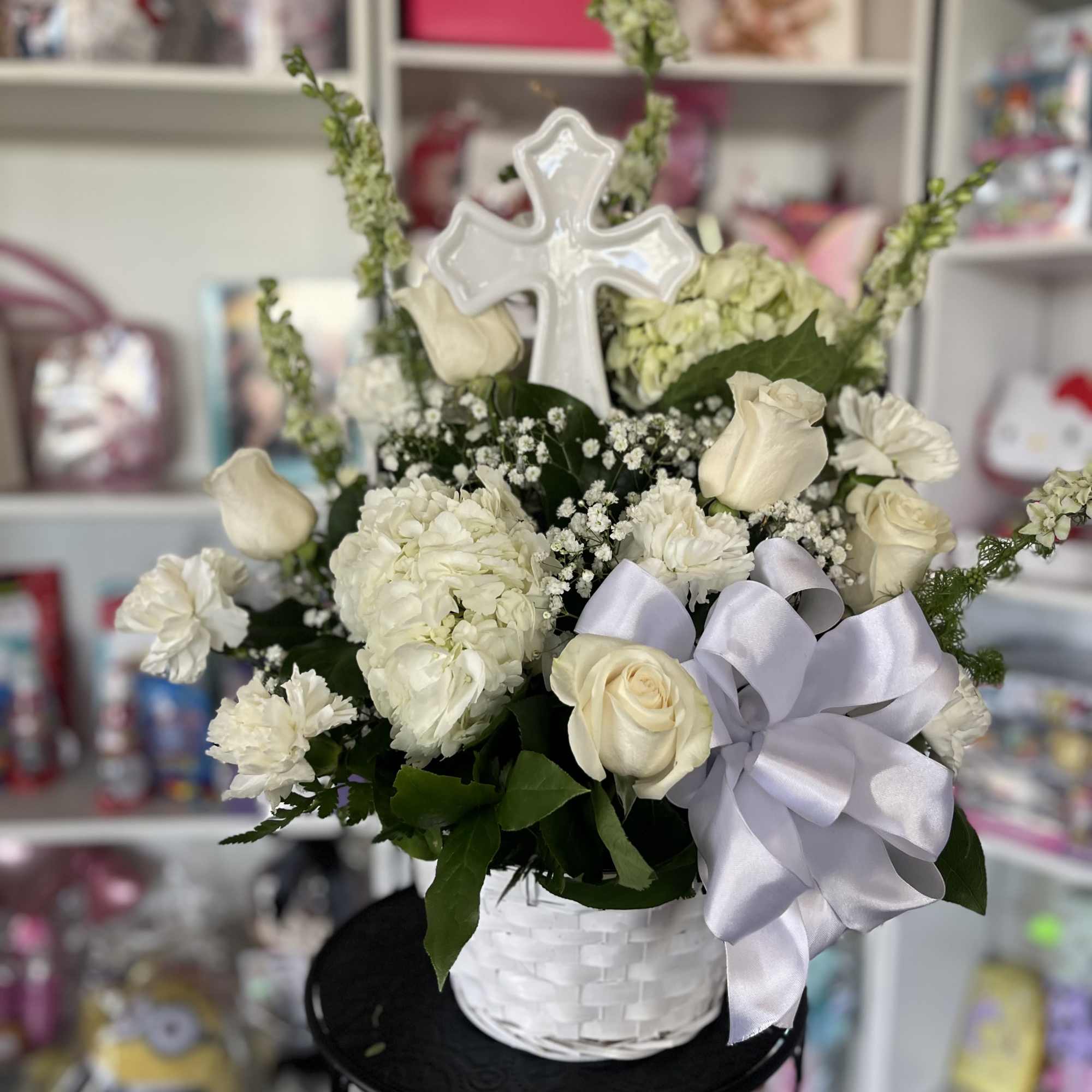 fresh white flowers in basket with large cross 