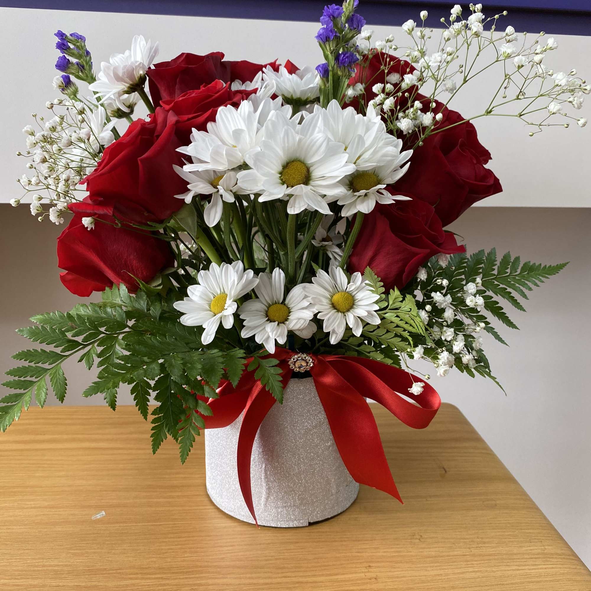 9 Red roses, some white daises, baby breath , and greenery, leatherleaf