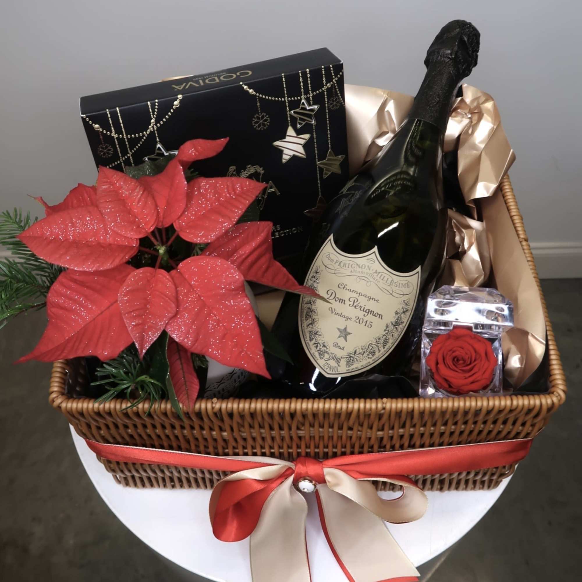 An elegant holiday gift basket featuring a premium bottle of Dom P&eacute;rignon