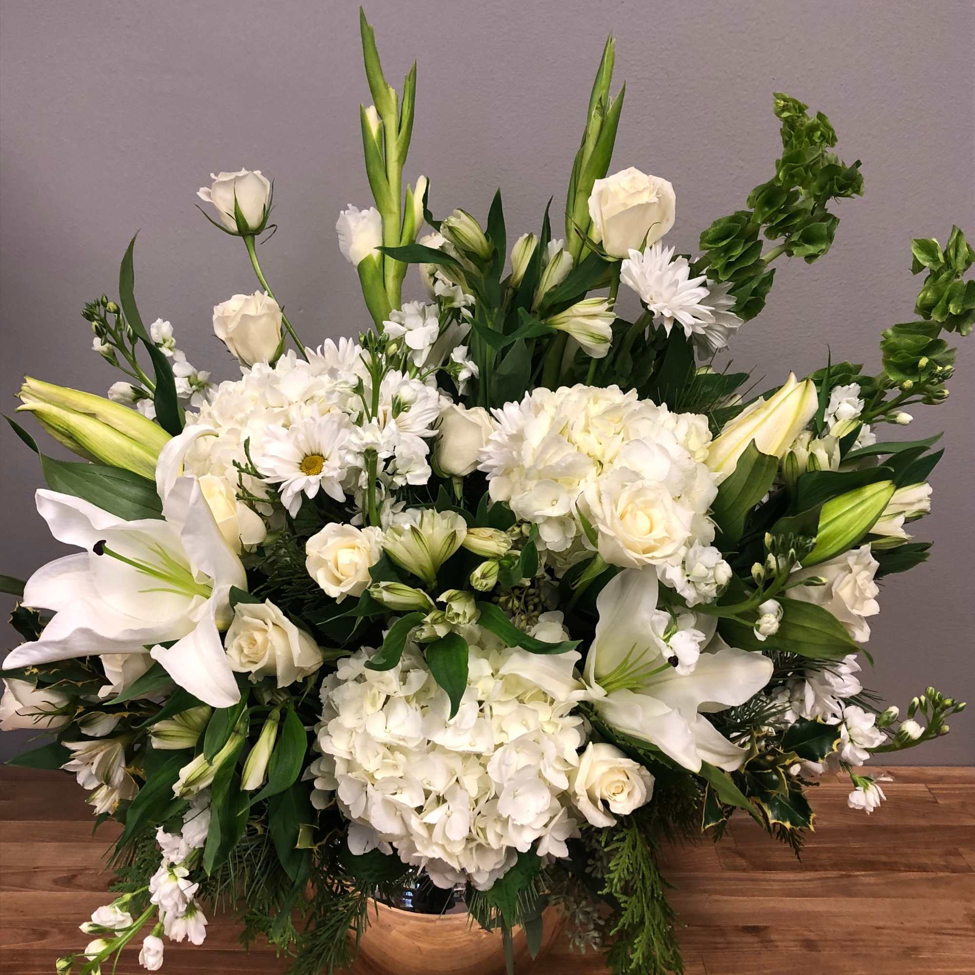 Full of assorted white flowers, accented with beautiful greens. Seasonal blooms and
