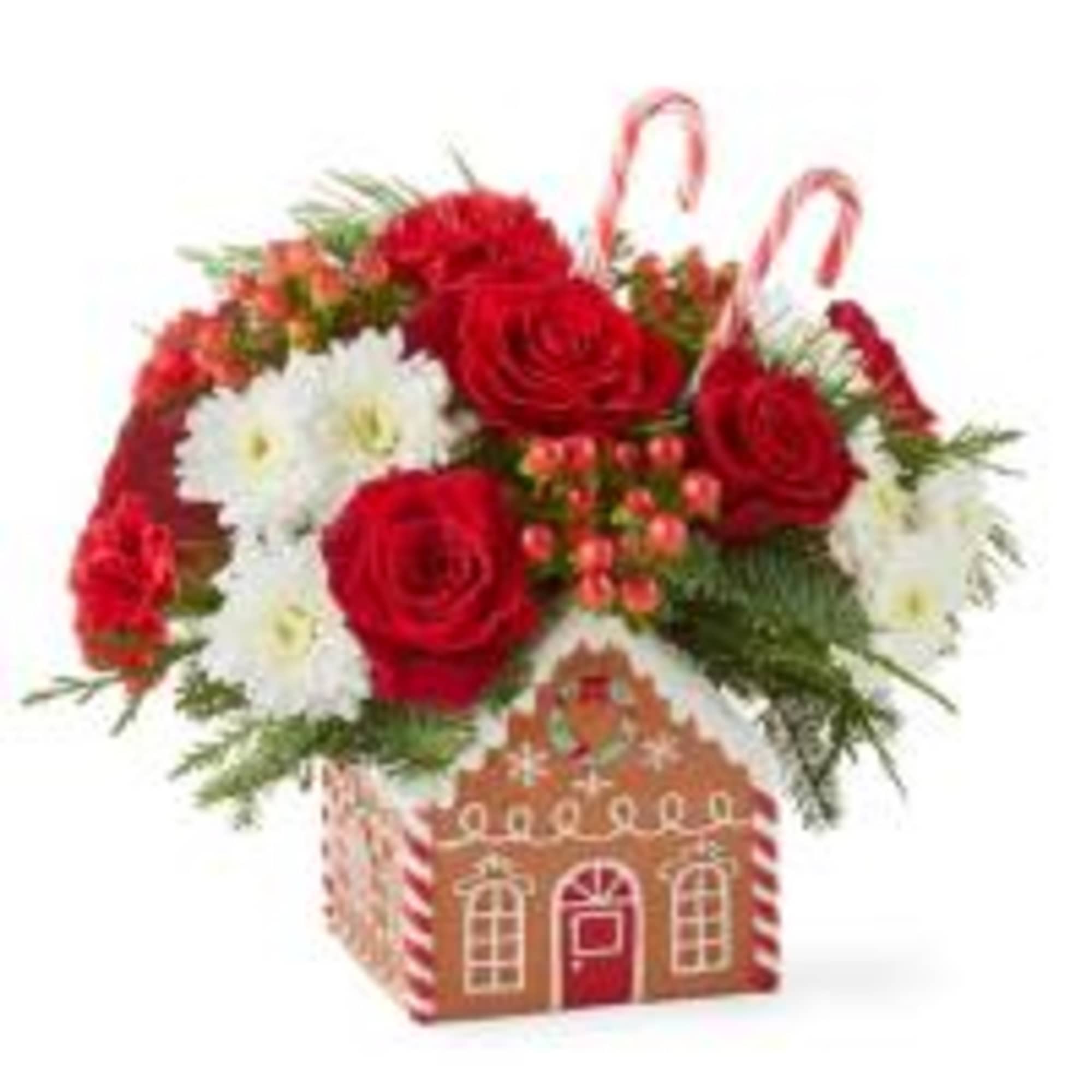 Classic Gingerbread house filled with Christmas greens, red roses, white mums, red