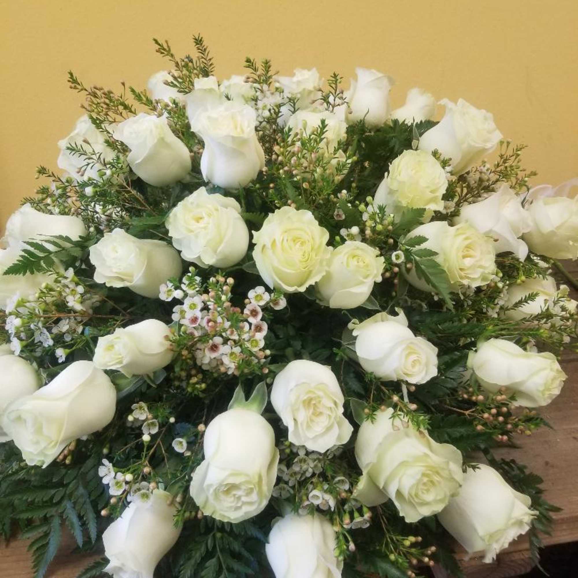 36 WHITE ROSES with Filler and WHITE BOW.  Casket measures about