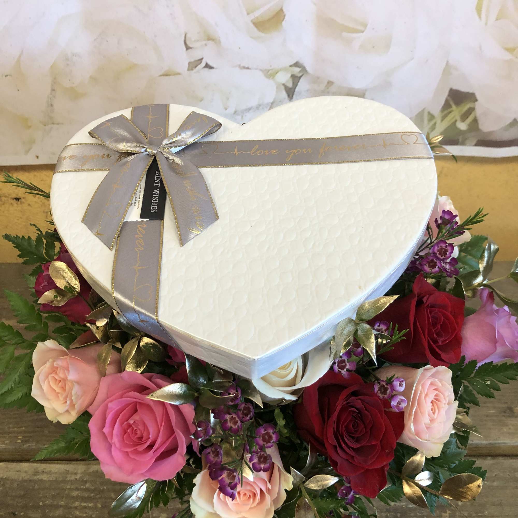 HEART SHAPE BOX WITH ONLY ROSES AND FILLERS .  THE ROSES