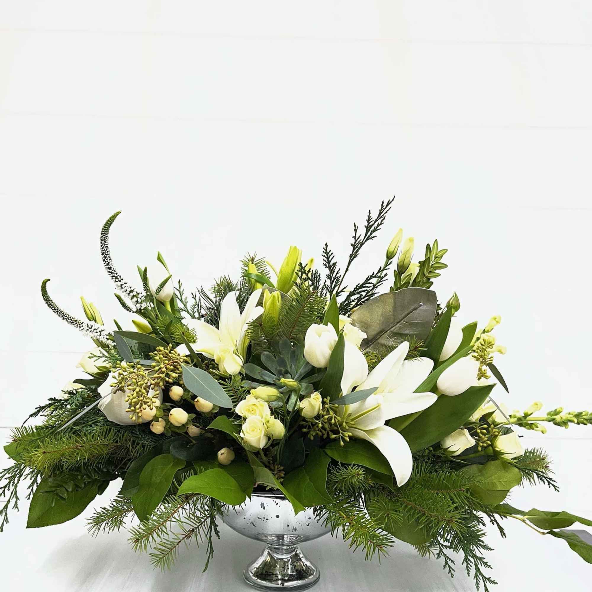 Fresh winter greens and snow-white blooms are paired to perfection in this