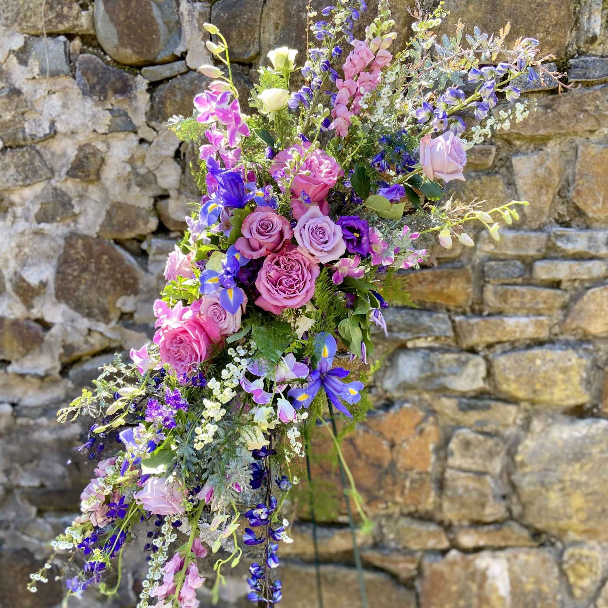 Seasonal florals and greenery reach towards the heavens to memorialize your loved