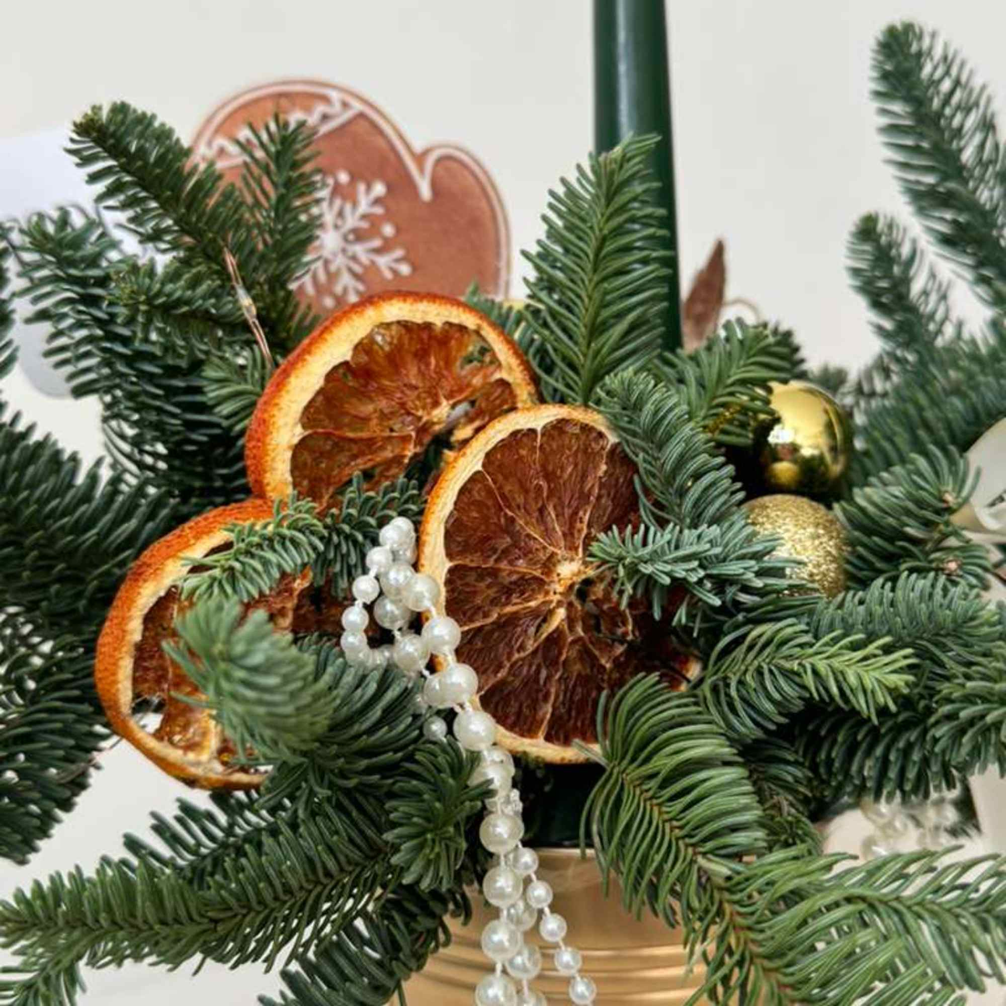 A chic holiday centerpiece featuring fresh evergreen branches in a gold pot