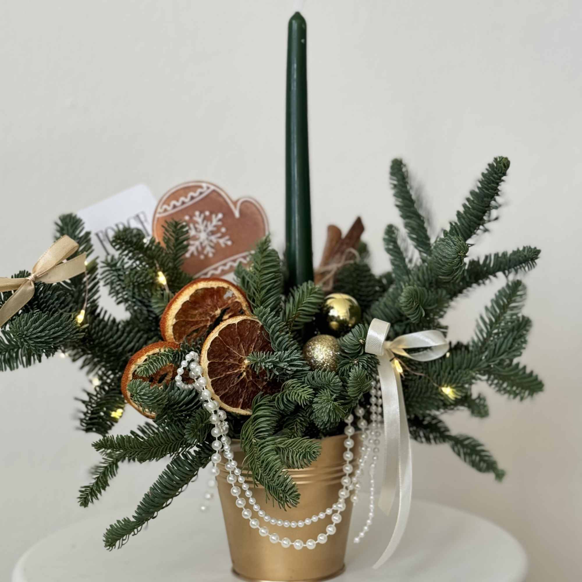 A chic holiday centerpiece featuring fresh evergreen branches in a gold pot