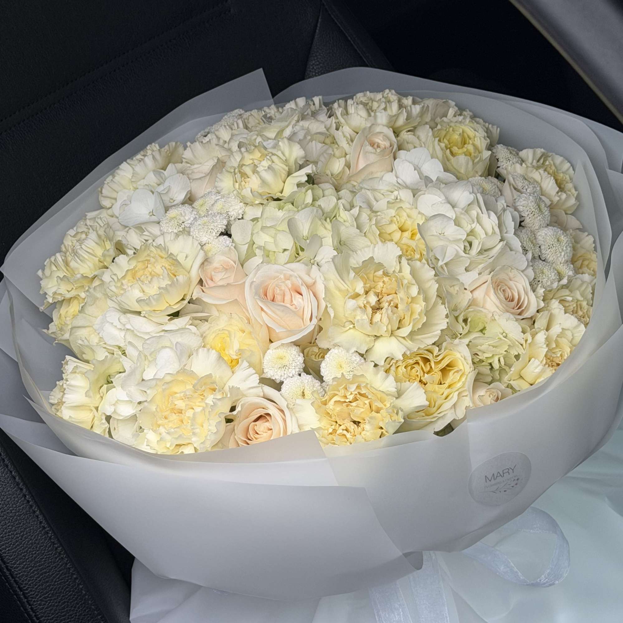 This refined arrangement features a harmonious blend of premium ivory and soft