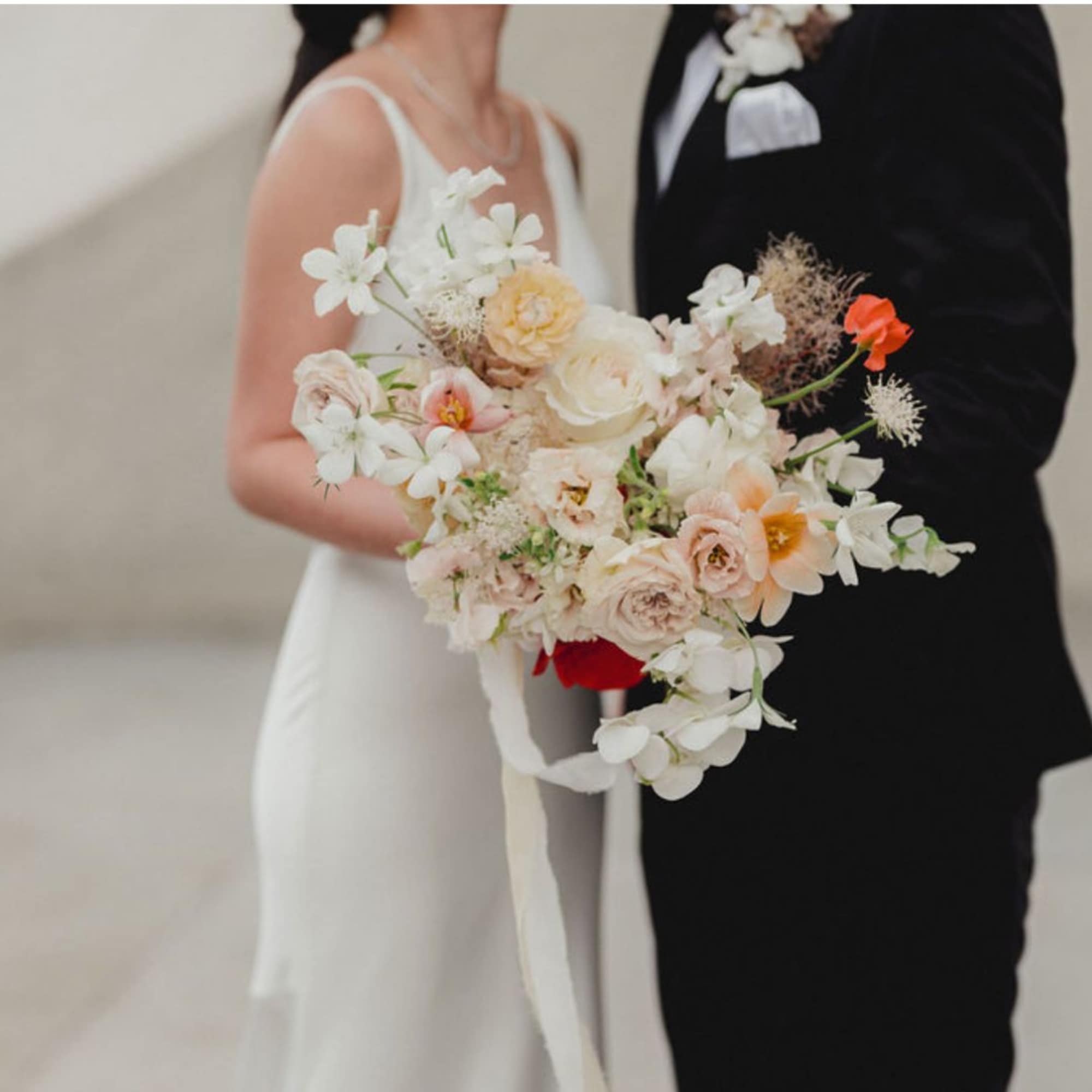 A large-scale bridal bouquet featuring elegant orchids and premium roses, designed in