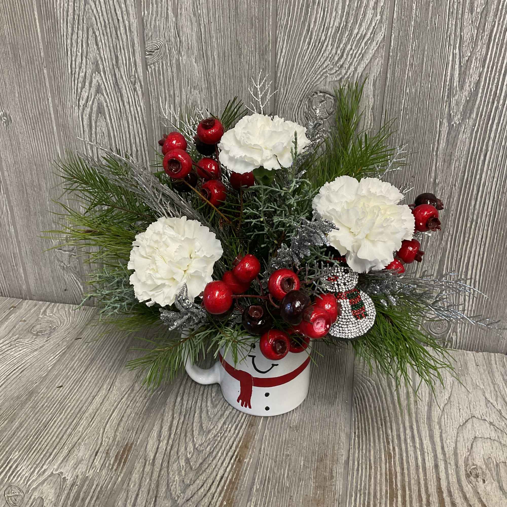 Fresh cut flowers arranged in a keepsake ceramic snowman mug! Includes a