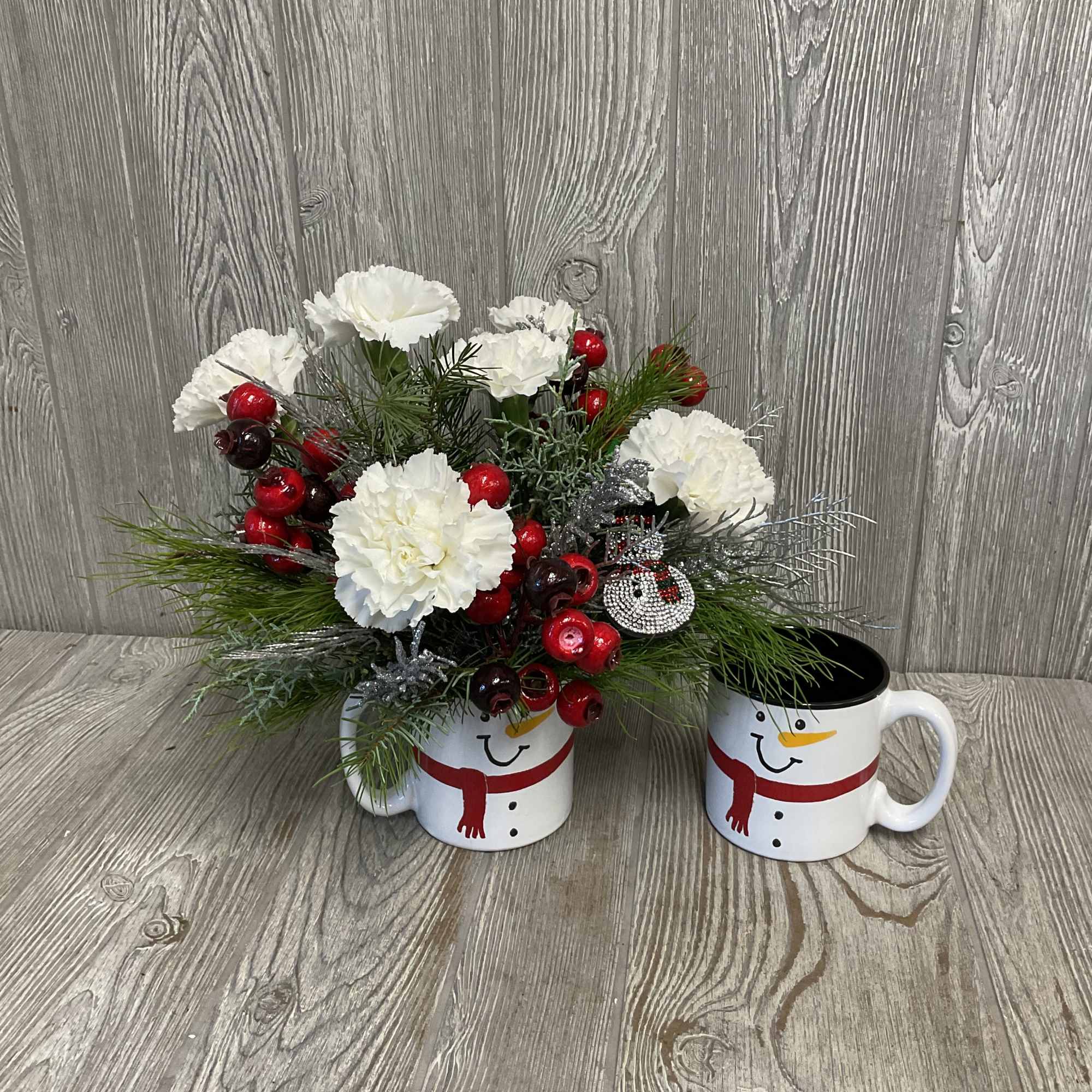 Fresh cut flowers arranged in a keepsake ceramic snowman mug! Includes a