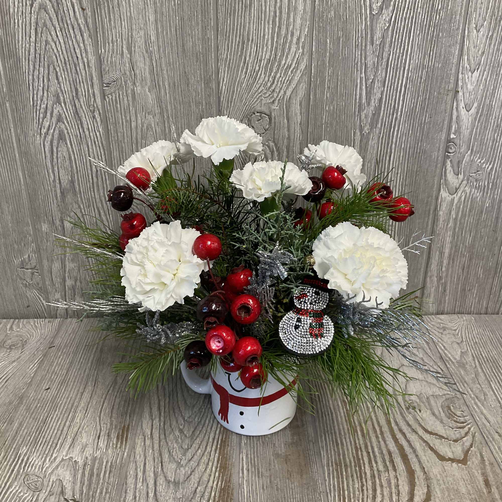 Fresh cut flowers arranged in a keepsake ceramic snowman mug! Includes a