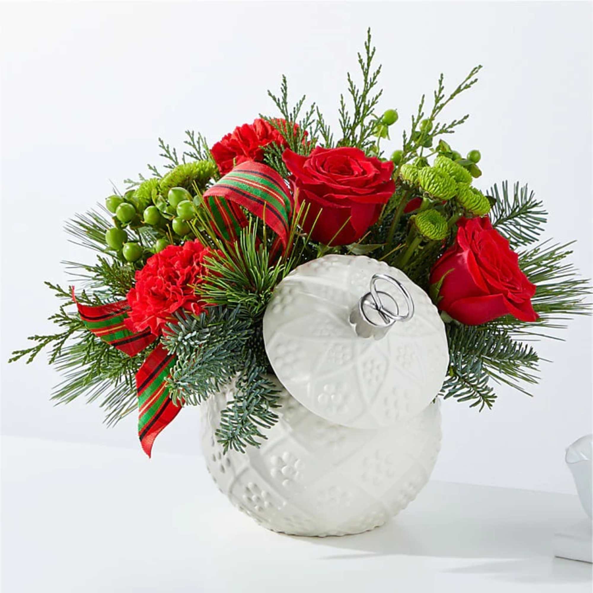 A festive Christmas floral arrangement designed with fragrant holiday greens, accented with