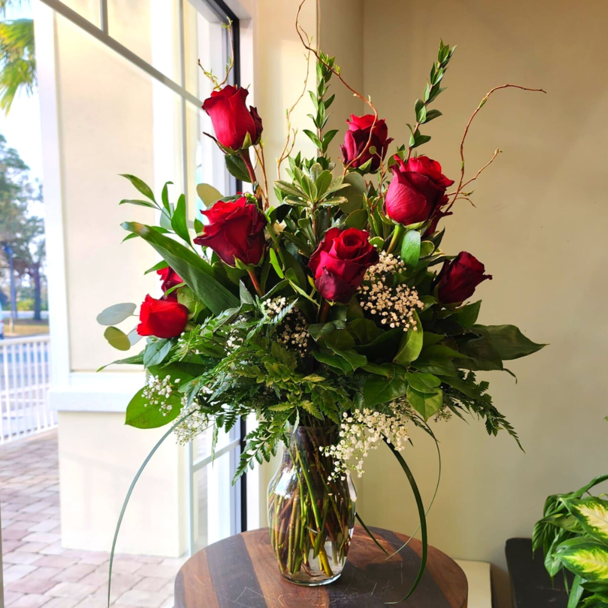 A timeless and elegant floral arrangement featuring premium long-stem red roses, accented