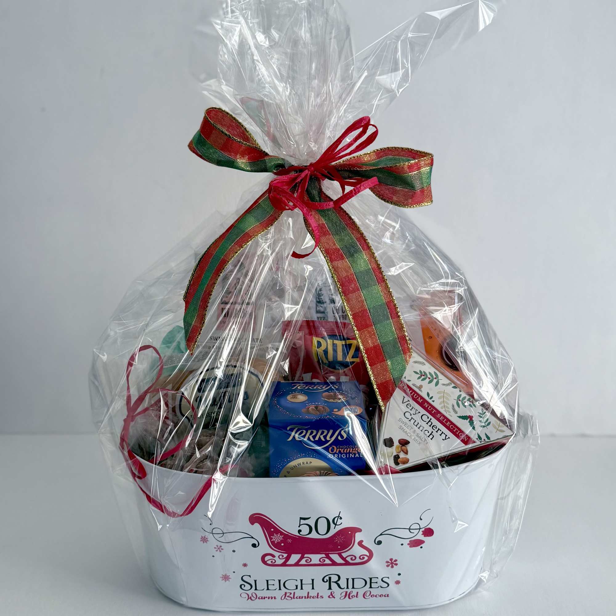 A metal sleigh ride container filled with a variety of snacks. Swissboy