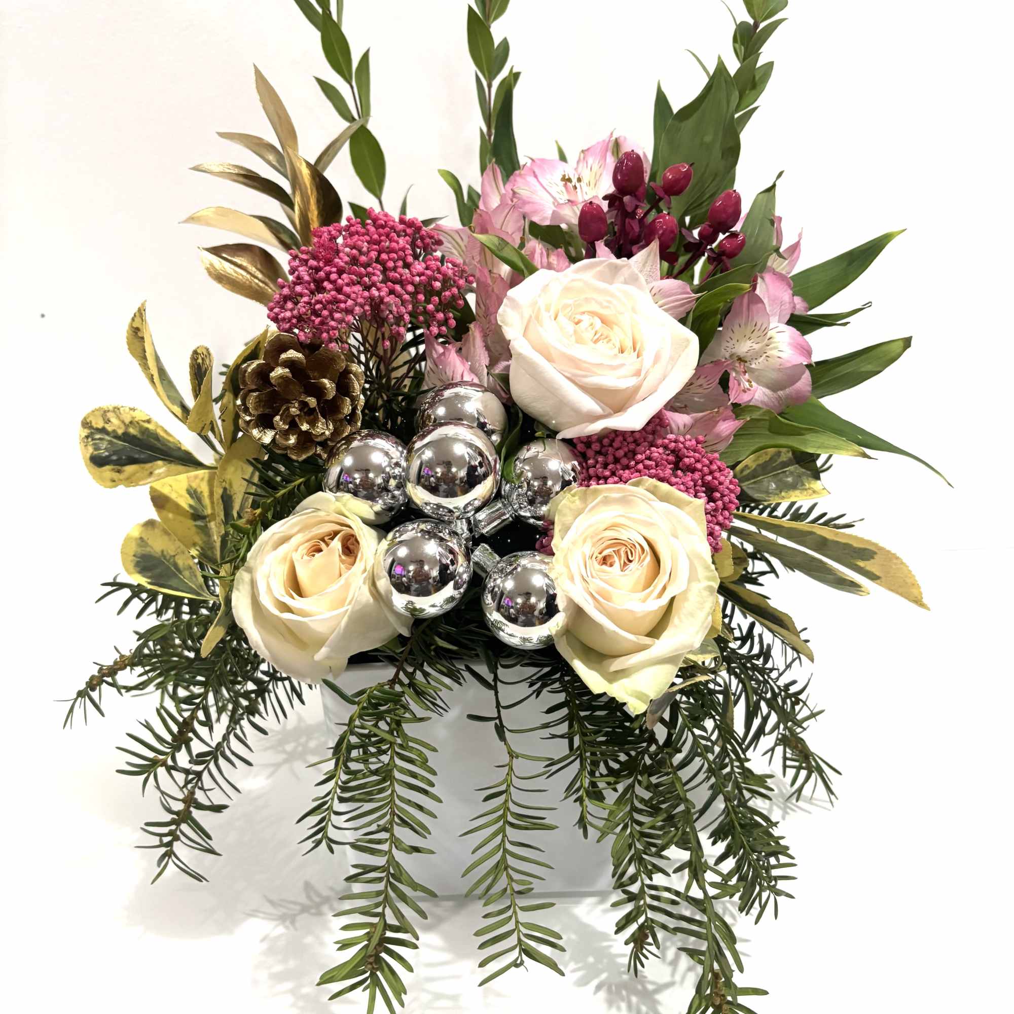 A refined festive floral arrangement featuring soft pink and cream roses, pink
