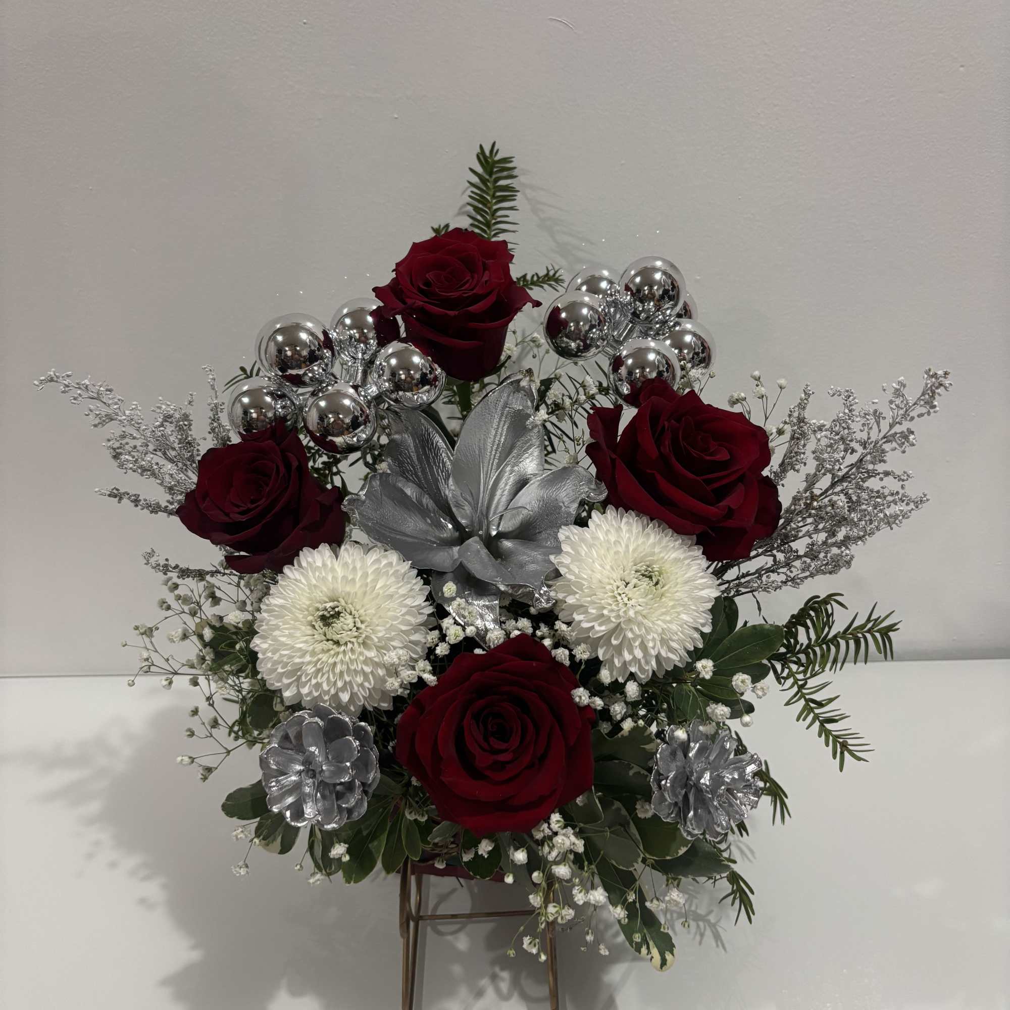 A delicate seasonal floral arrangement that blends red and white blooms with