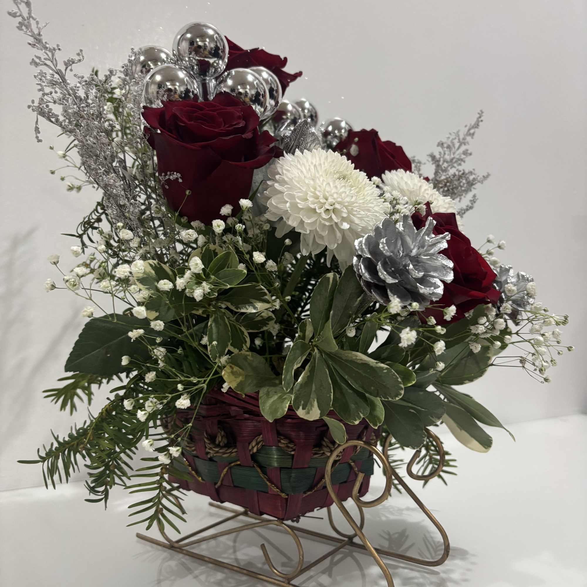 A delicate seasonal floral arrangement that blends red and white blooms with