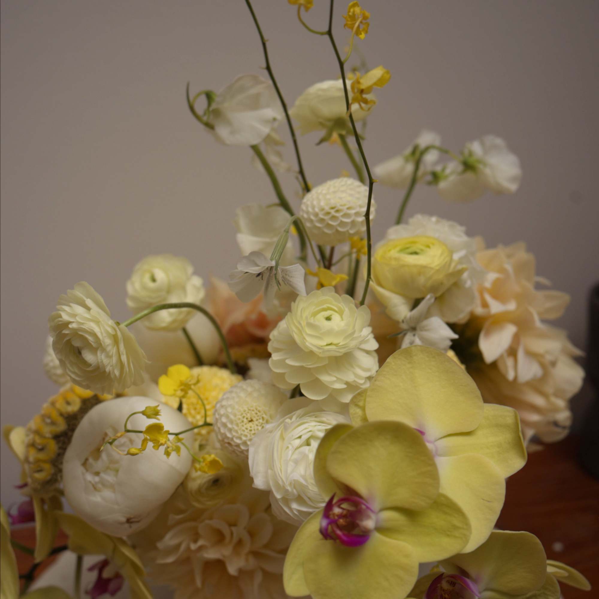 An all-yellow floral arrangement designed with a clean, modern aesthetic. 
Featuring seasonal