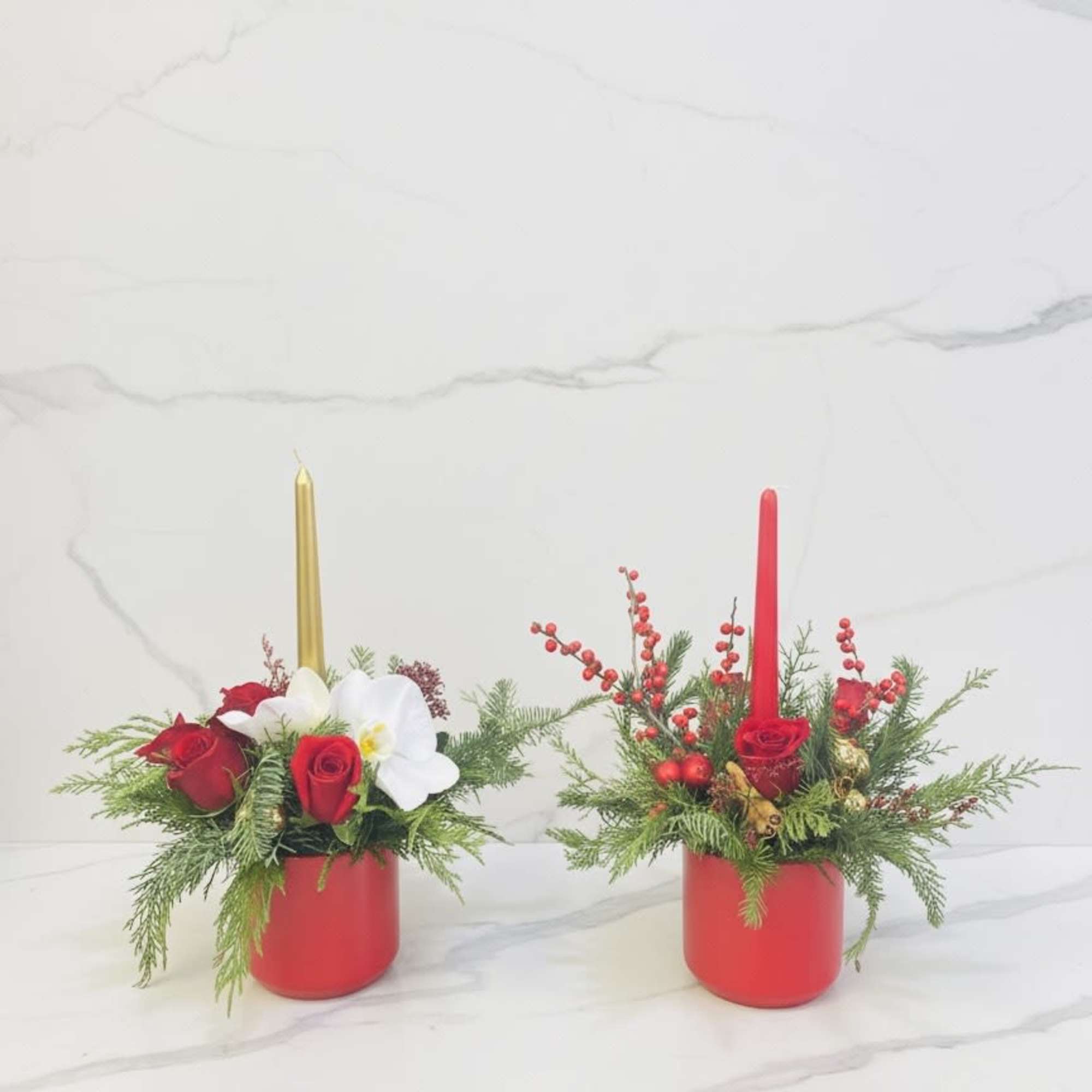 A charming holiday floral arrangement featuring fresh red roses, seasonal evergreens, decorative