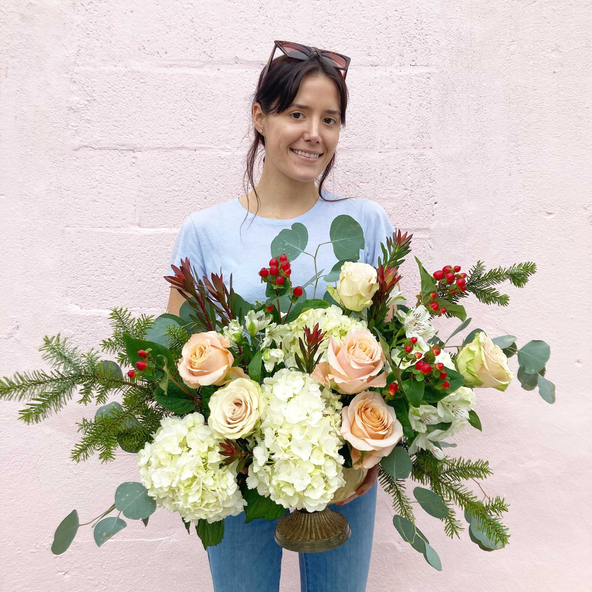 Fluffy white hydrangeas, peach and nude garden roses, winter greens and red