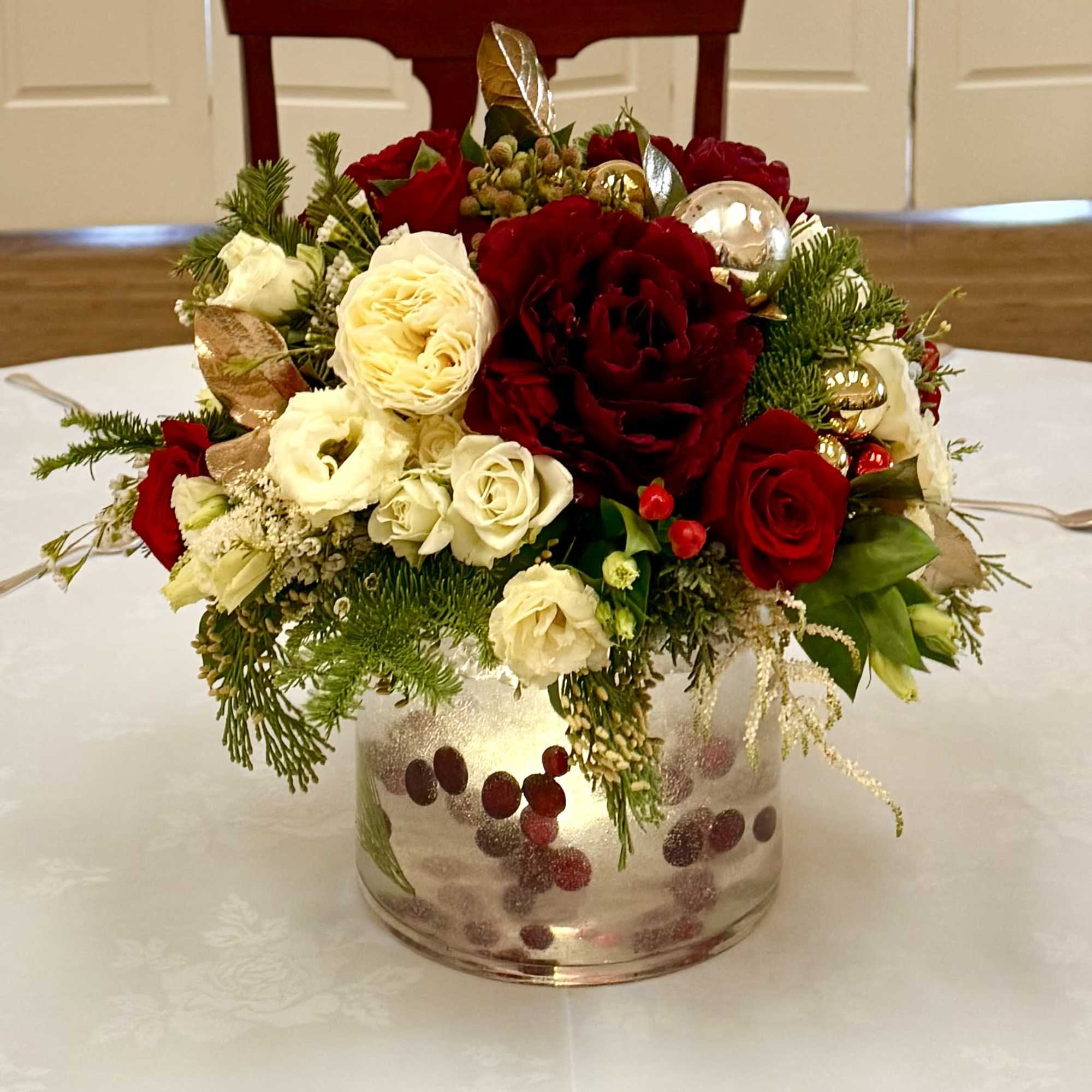 Beautiful arrangement with peonies, roses, ornaments, evergreens and berries 
Made in oases