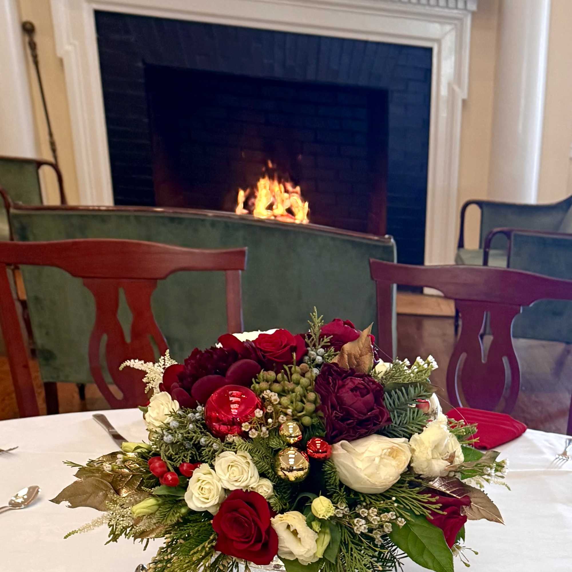 Beautiful arrangement with peonies, roses, ornaments, evergreens and berries 
Made in oases