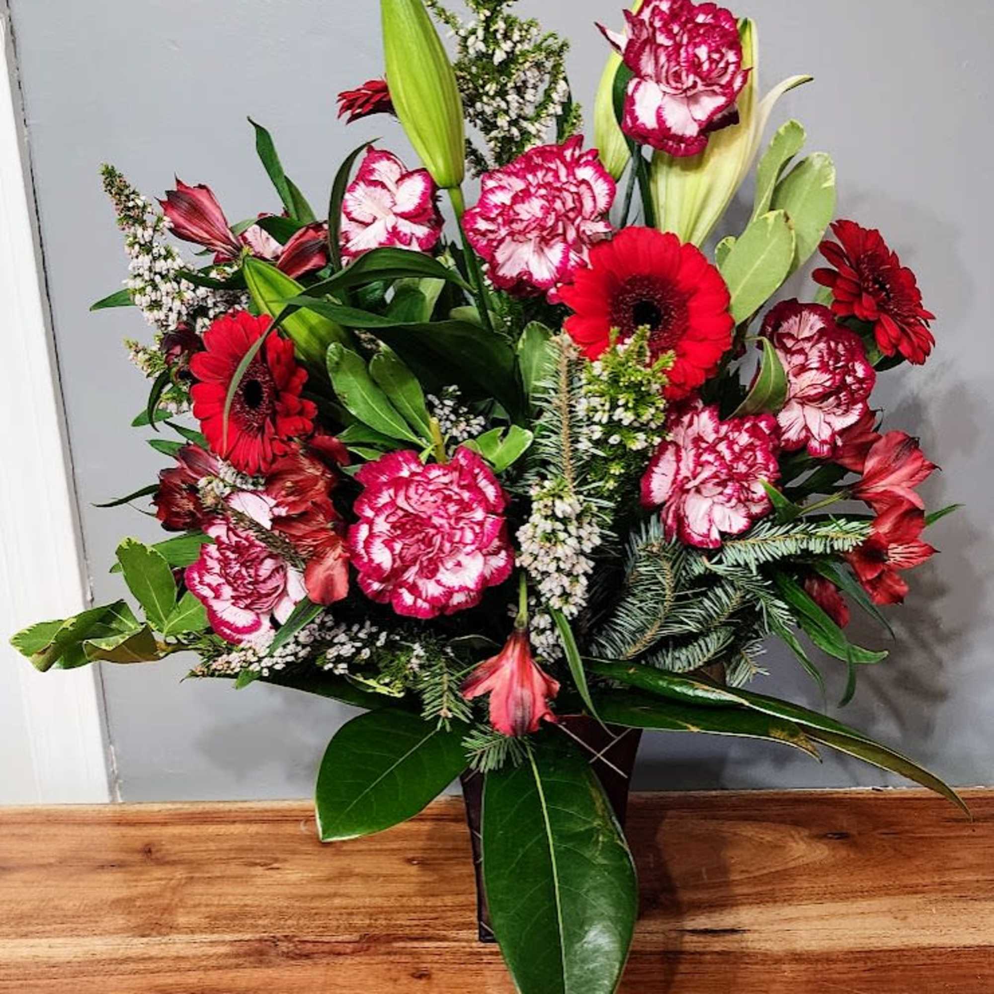 This Arrangement presents beautiful Gergera Daisies and lillies with fresh Magnolia Leaves.