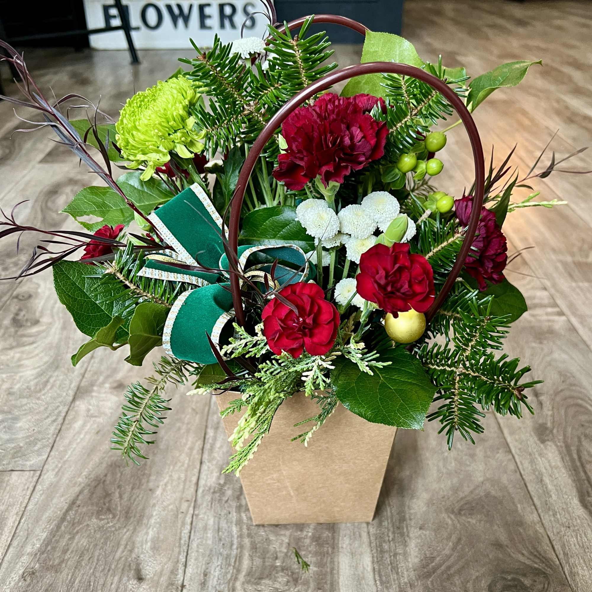 A festive arrangement in a brown bag container. 