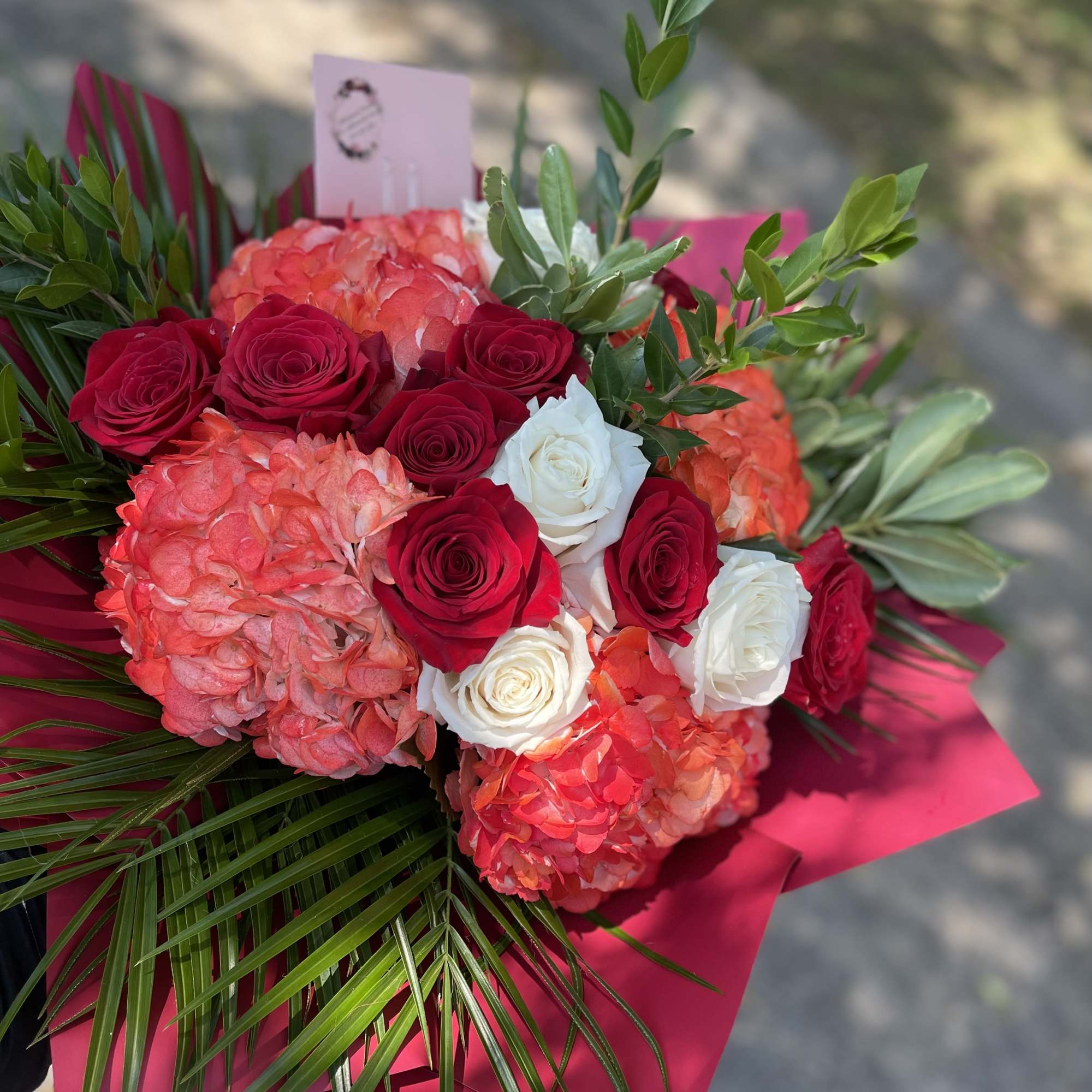 7 red roses 5 white roses and three red/orange hydrangeas with palm