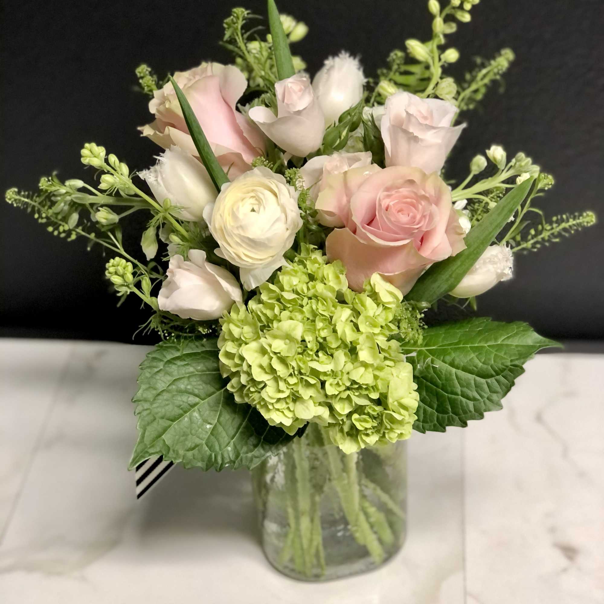 A garden mix with season's prettiest soft pink and white blossoms. Arranged