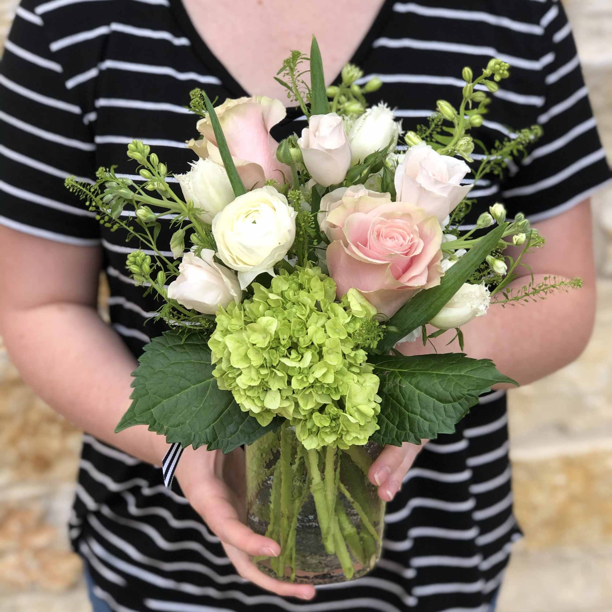 A garden mix with season's prettiest soft pink and white blossoms. Arranged