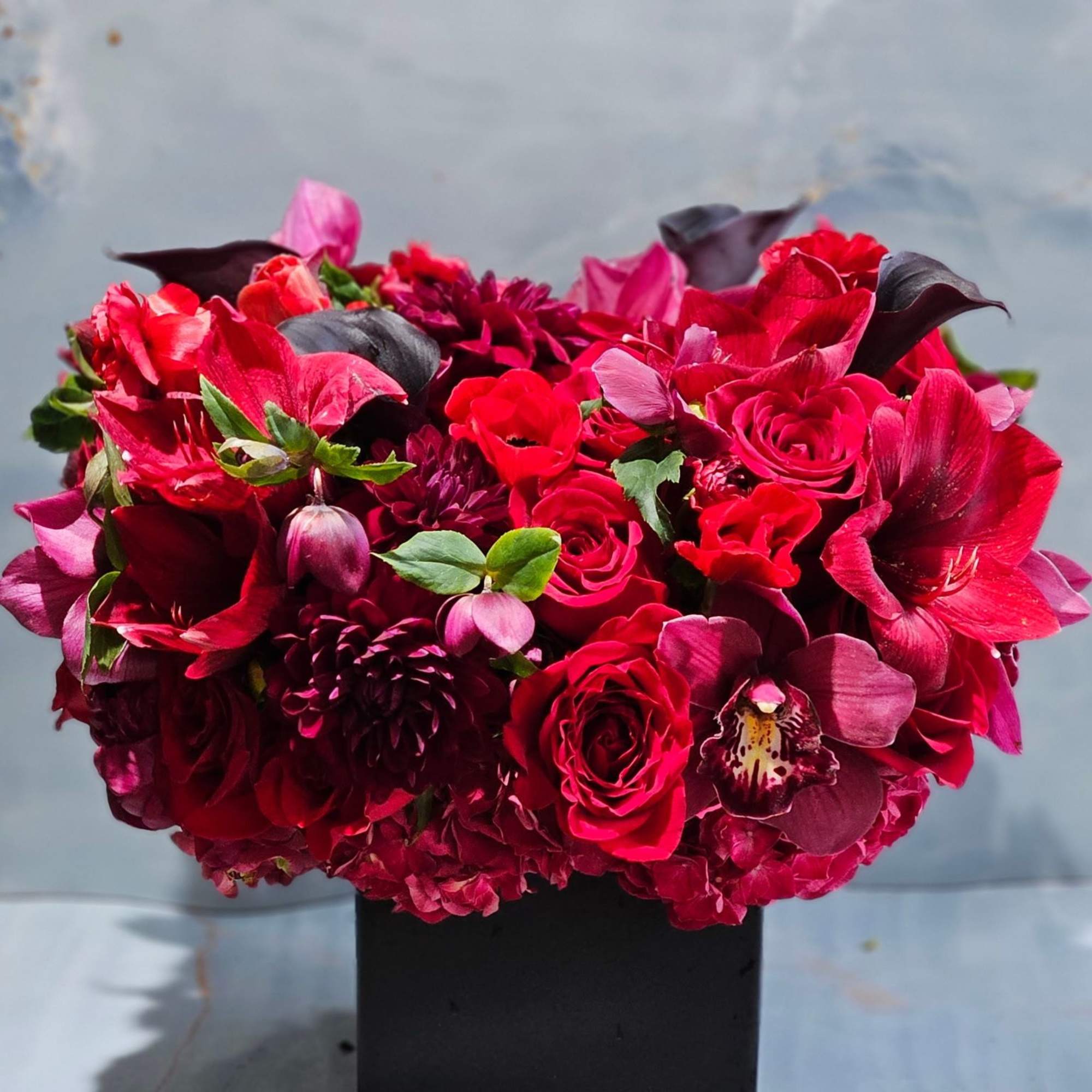 This striking floral arrangement is a lush, modern composition designed to make