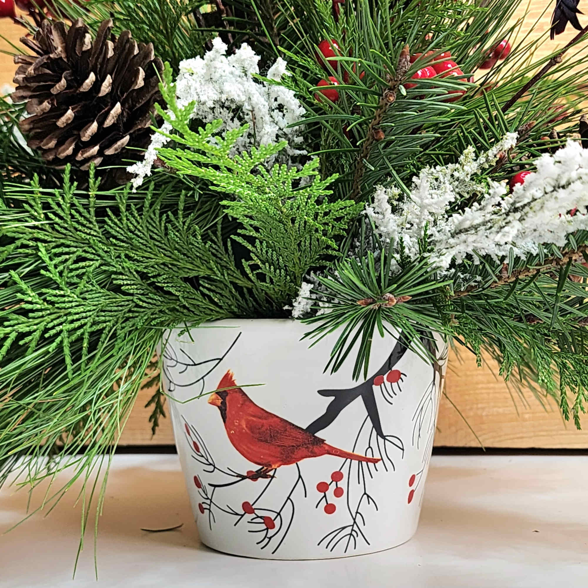 Cardinal Christmas is a delightful arrangement for the winter season, with a