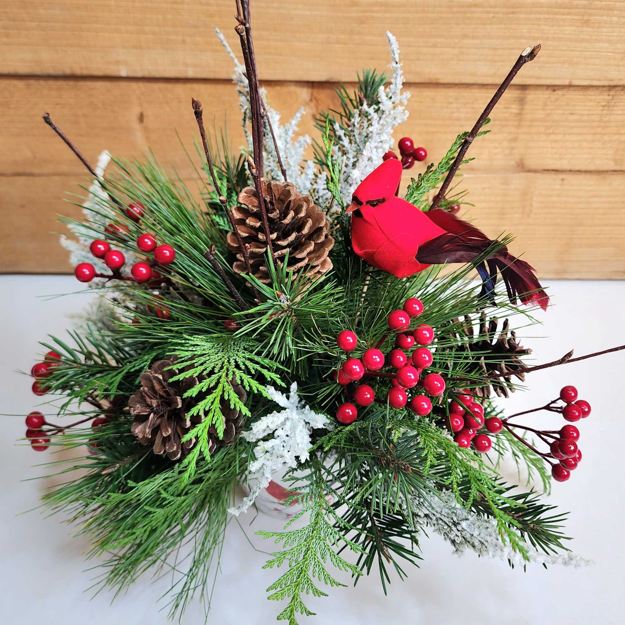 Cardinal Christmas is a delightful arrangement for the winter season, with a