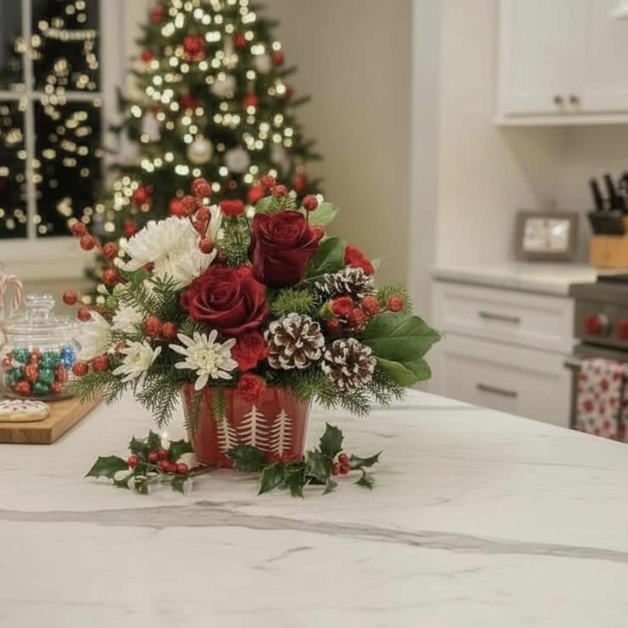 Evergreen Charm Centerpiece lights up the holidays with red roses, white blooms