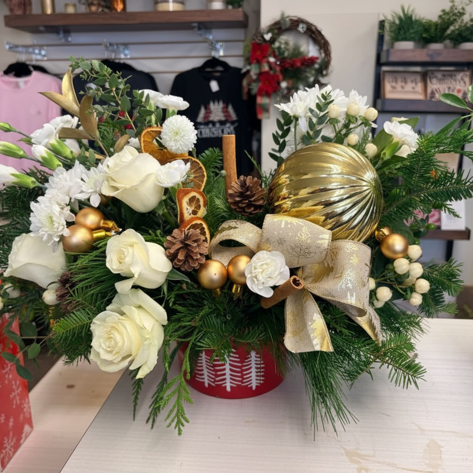 Evergreen Charm Centerpiece lights up the holidays with red roses, white blooms