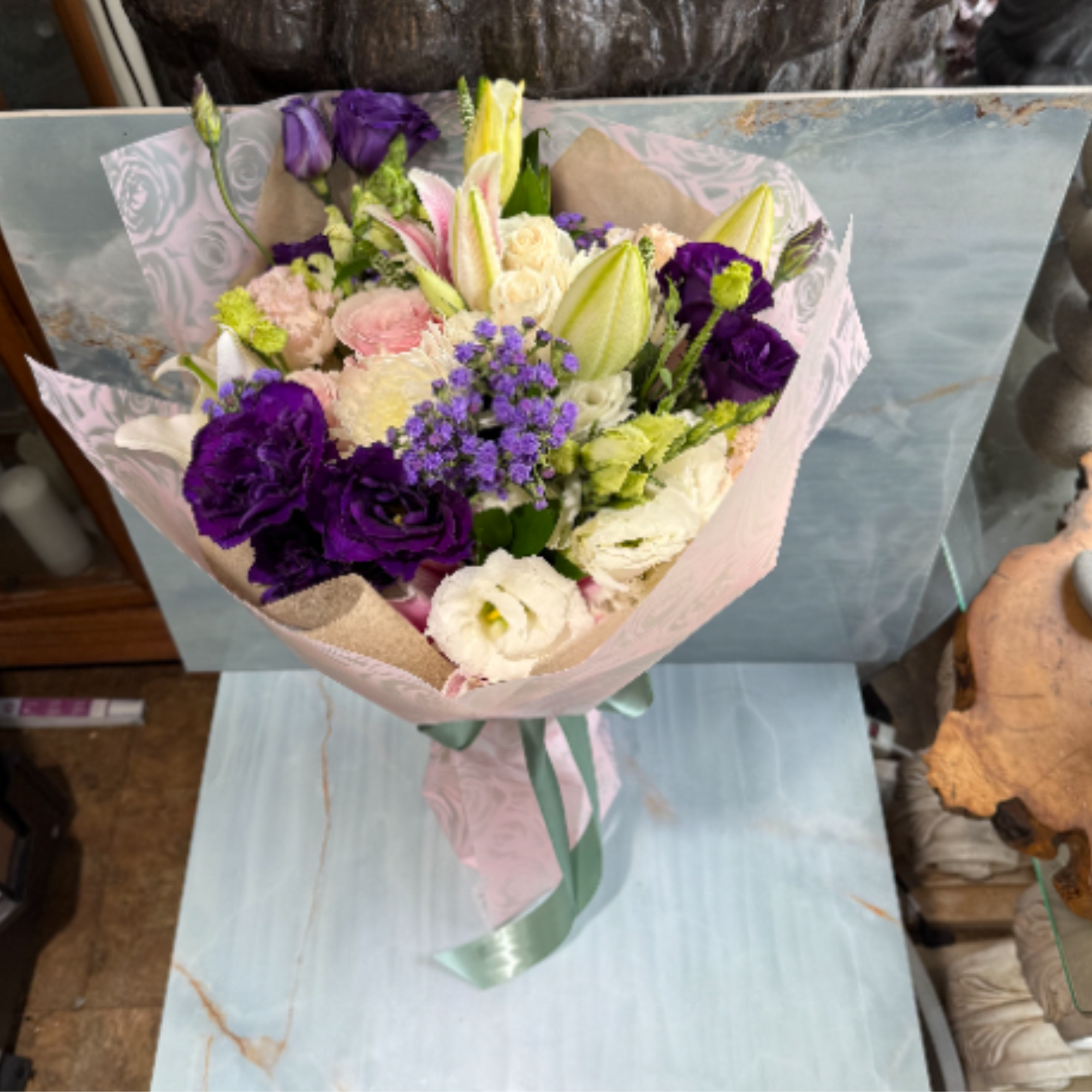 This bouquet features a soft, elegant palette with pops of rich color.