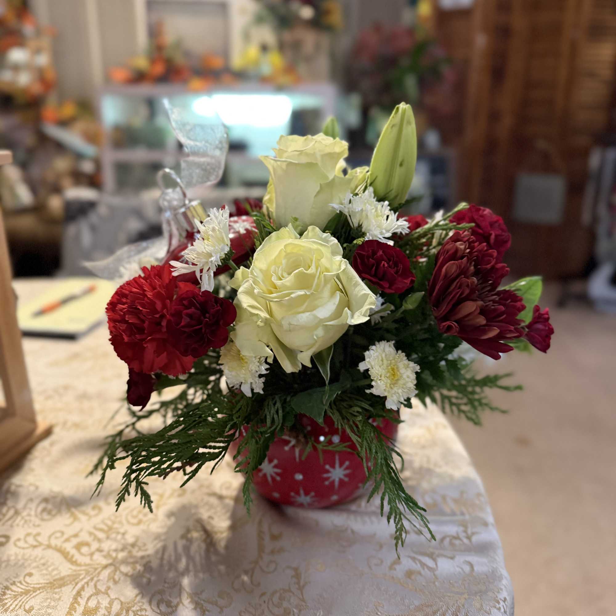 Fresh variety of festive Holiday colored flowers and Christmas greenery in a