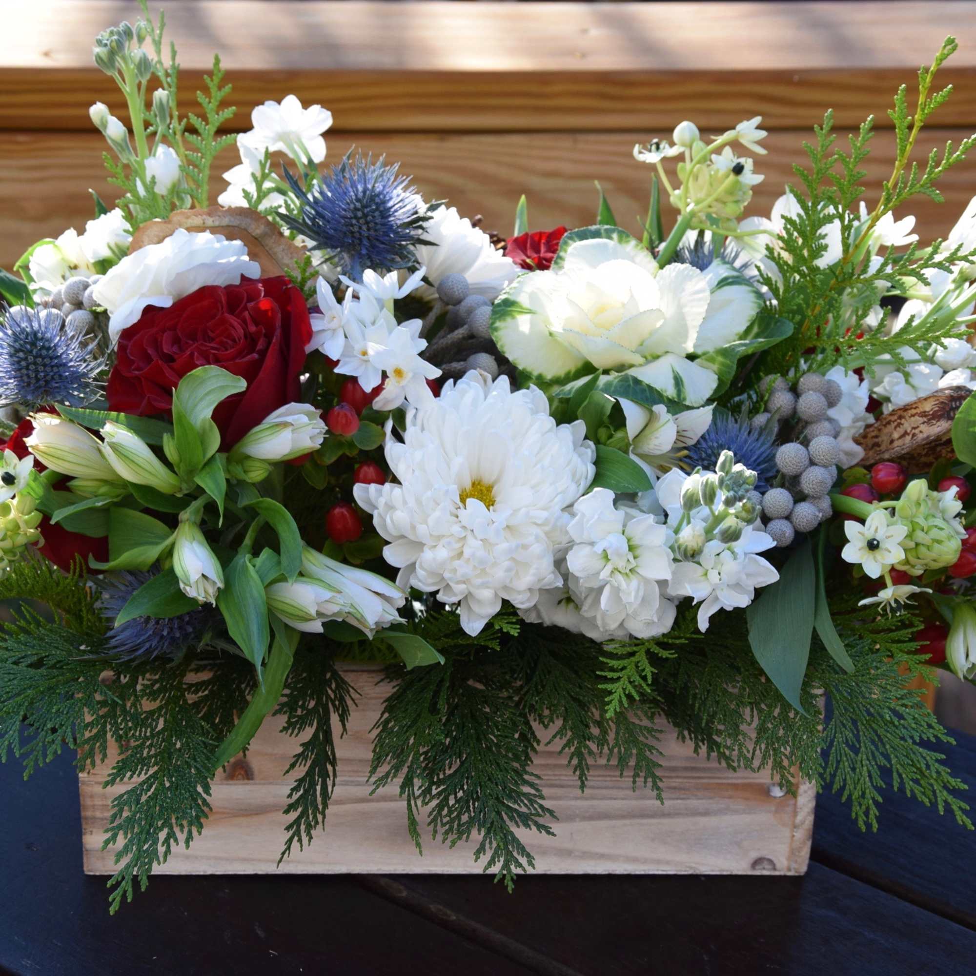 A rich mix of seasonal flowers in variety of winter/holiday colors arranged