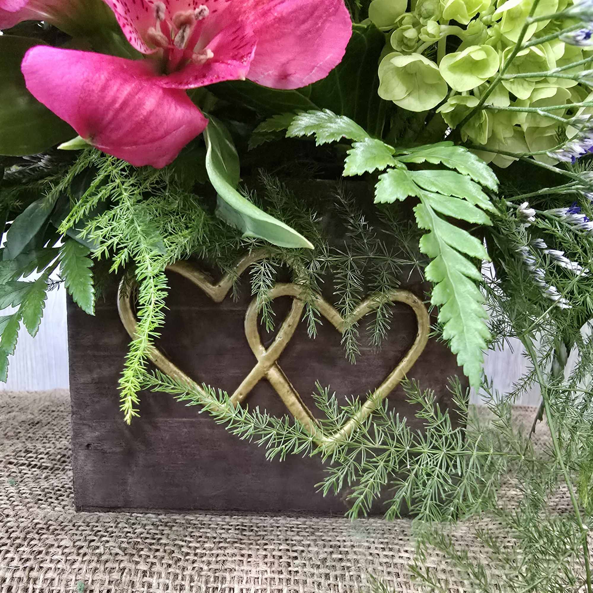 A gorgeous arrangement arranged in a wooden box complimented with gold hearts.