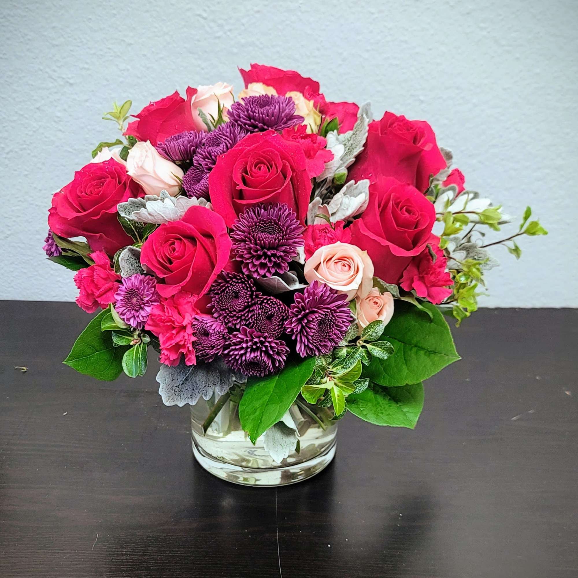 This stunning arrangement features deep red Roses, complemented by vibrant pink Carnations