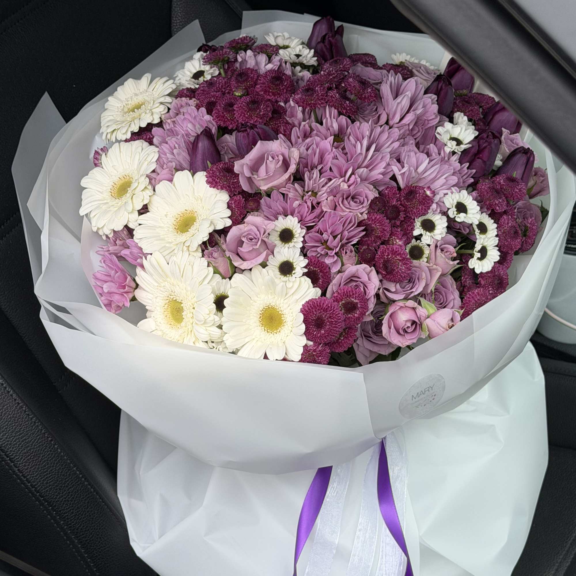 This exquisite floral arrangement features a harmonious blend of soft lavender, rich