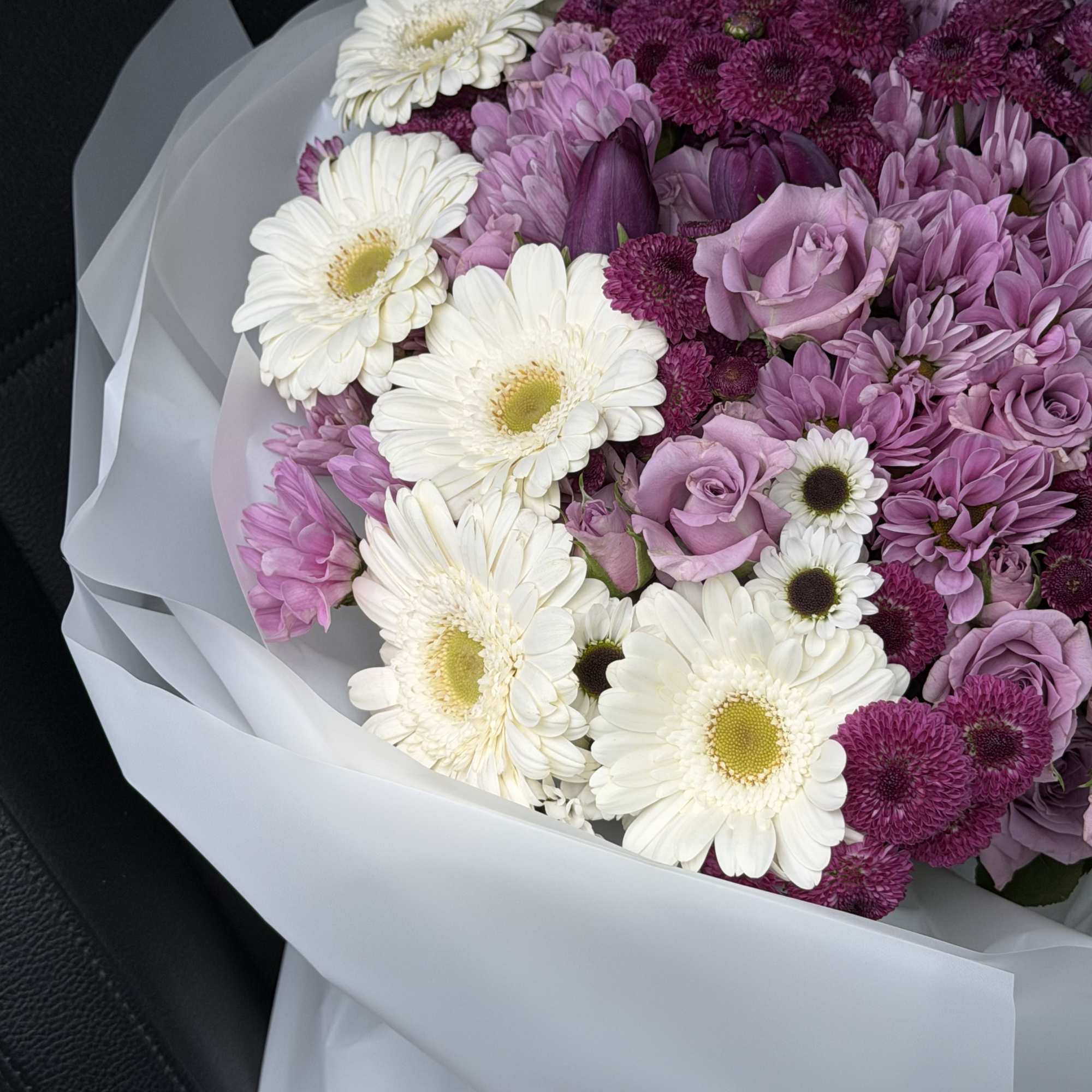 This exquisite floral arrangement features a harmonious blend of soft lavender, rich