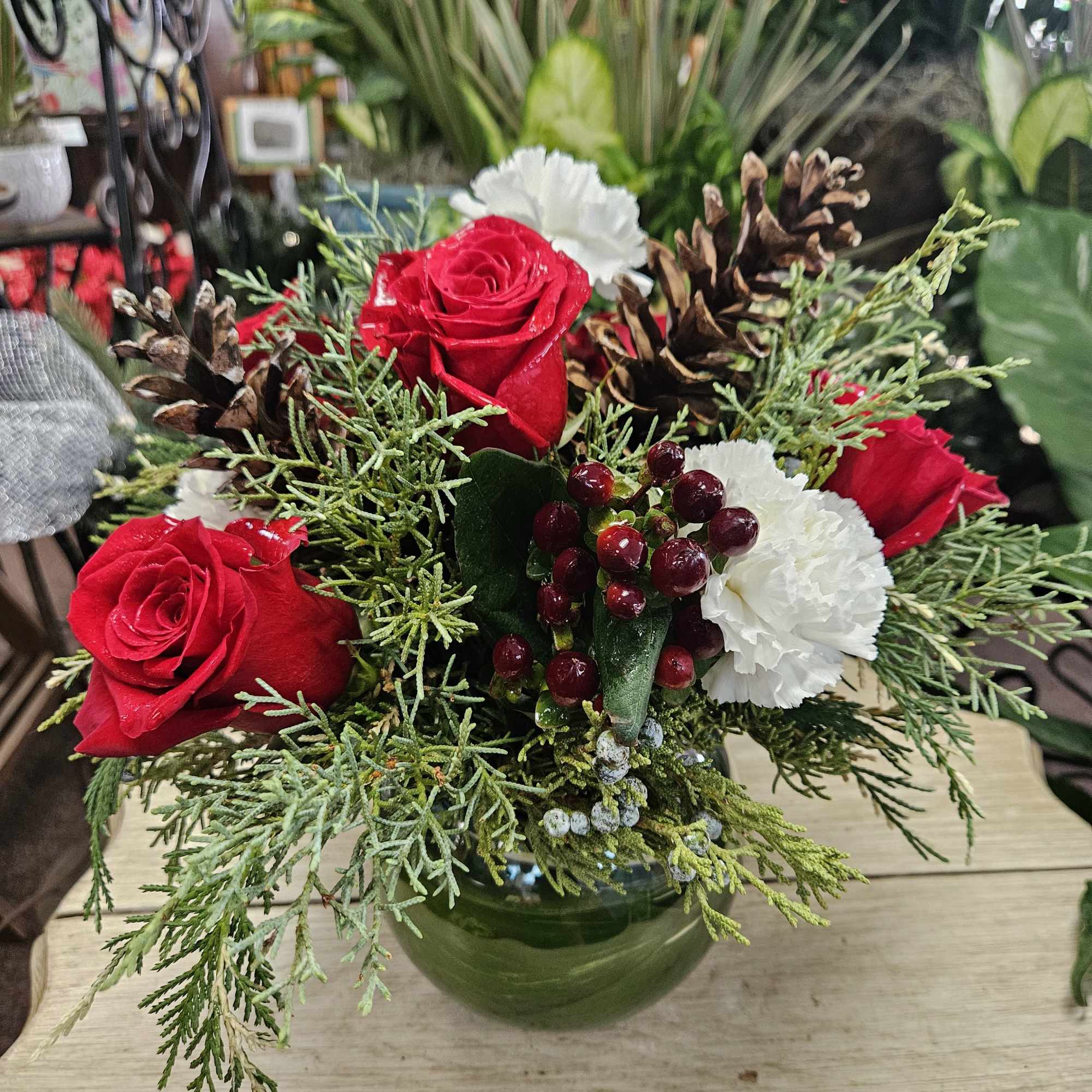 An elegant rose bowl filled with festive flowers and foliage makes this
