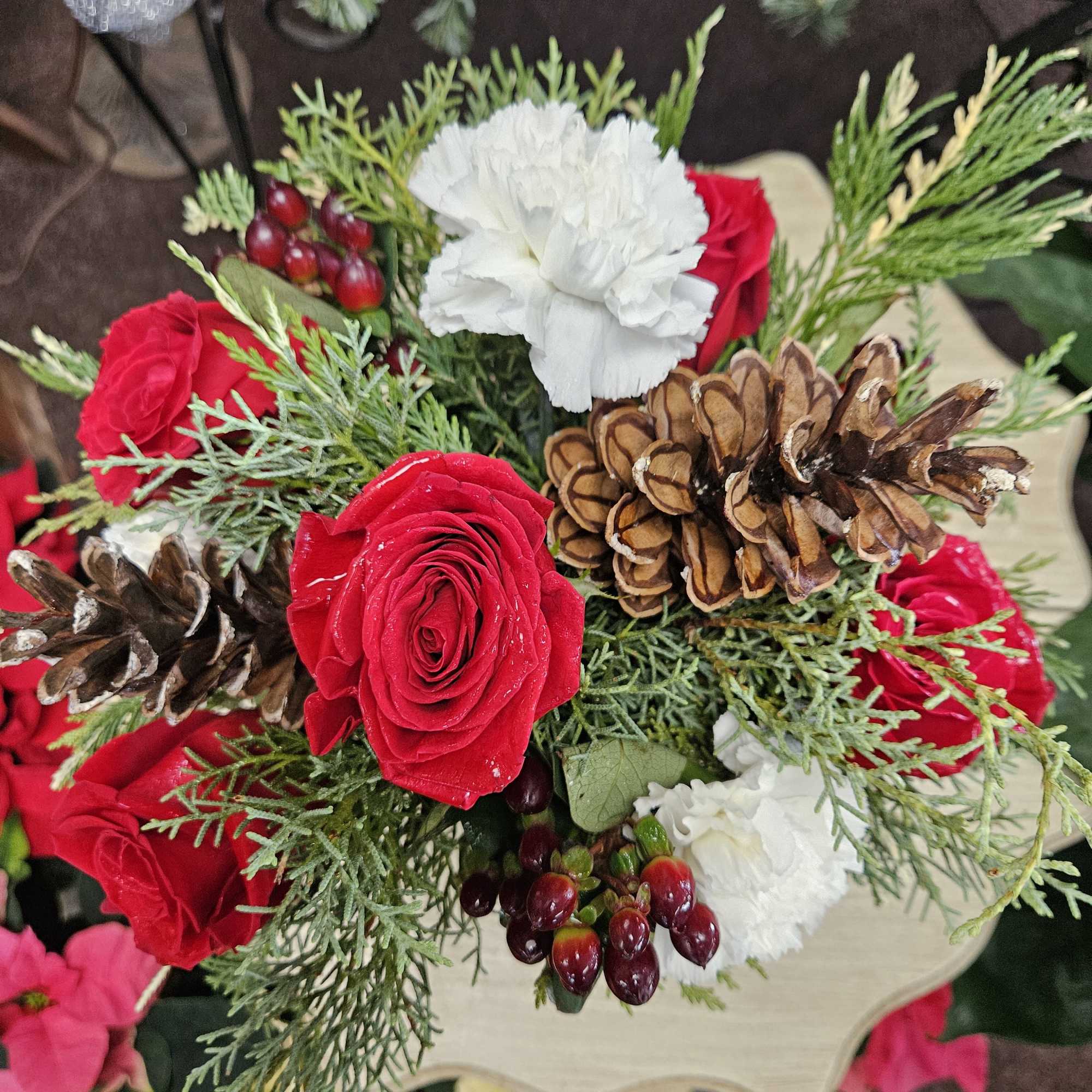 An elegant rose bowl filled with festive flowers and foliage makes this
