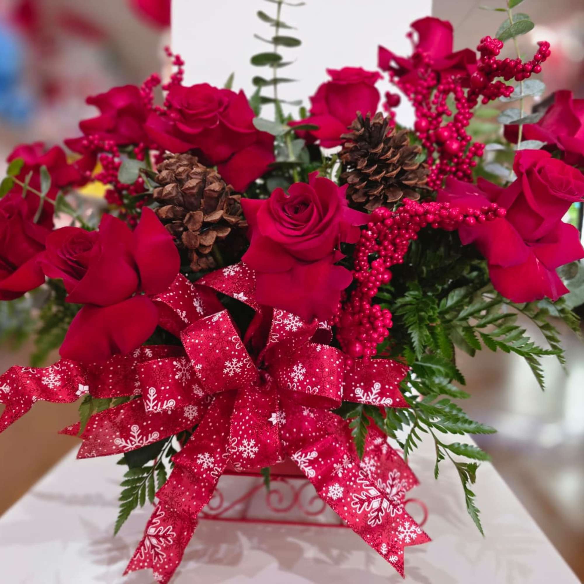 Beautiful Christmas sleigh made of red roses, decorated with mini red cherries