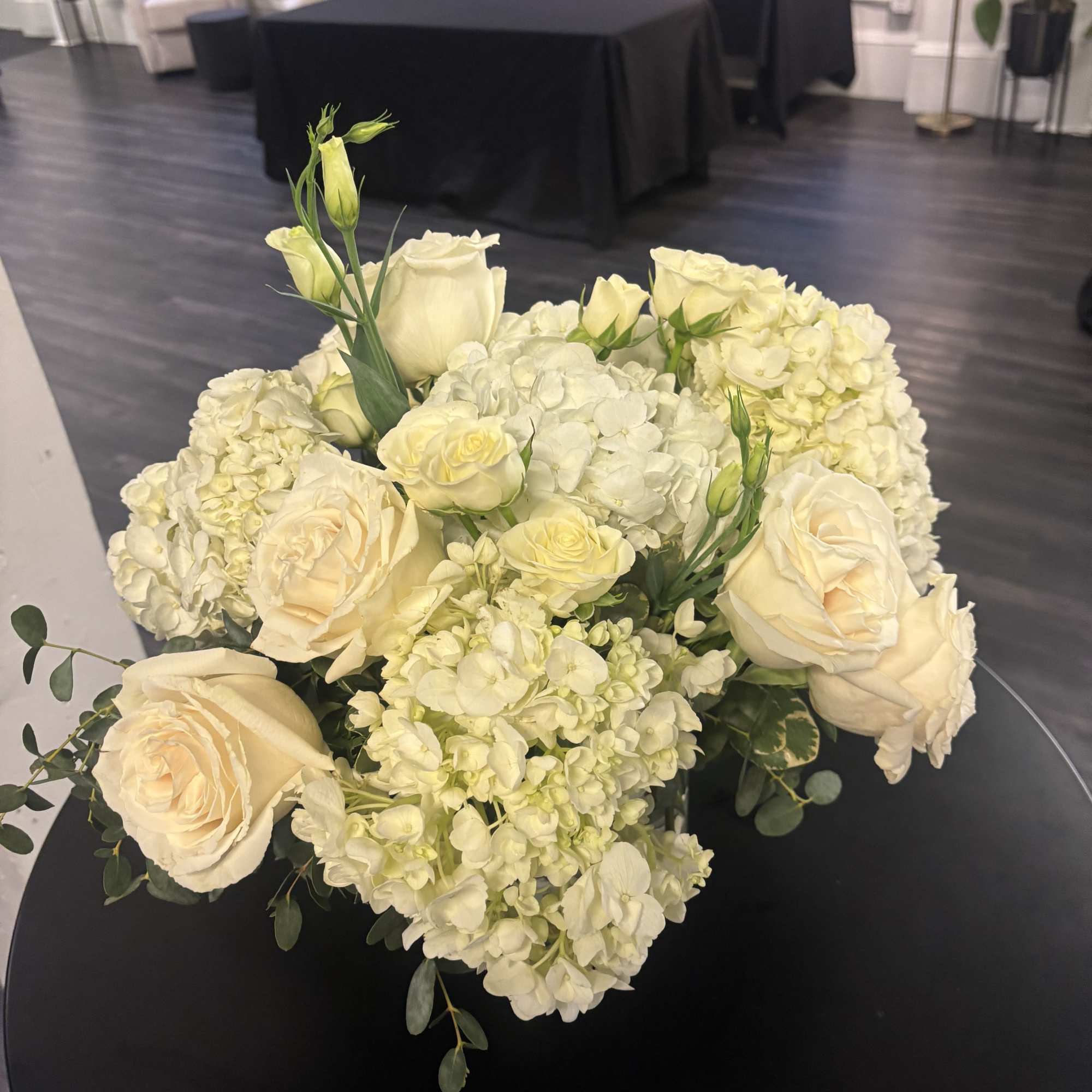 New beginnings deserve flowers! This all white arrangement includes roses, lisiantus and