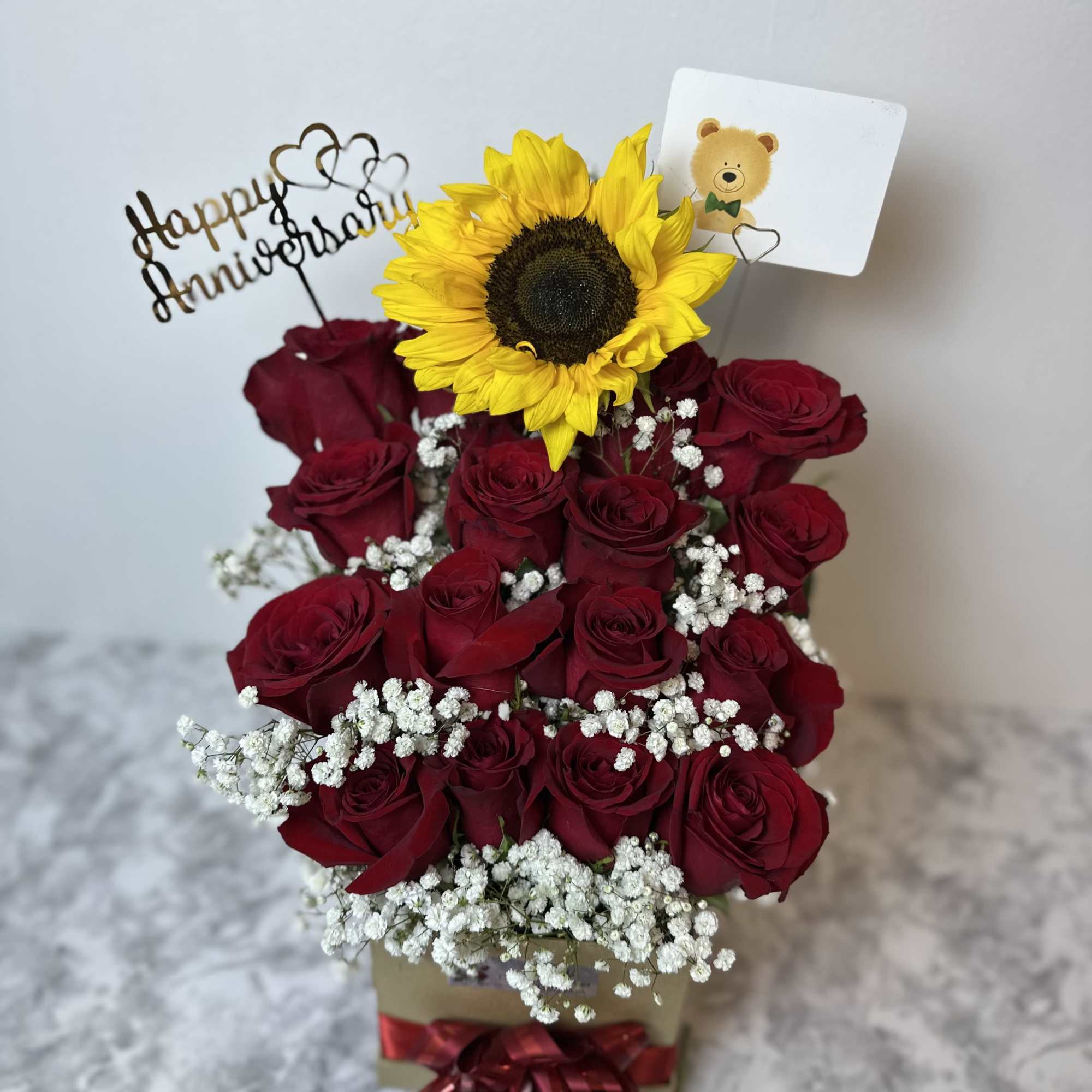 Box with 16 roses and 1 sunflower